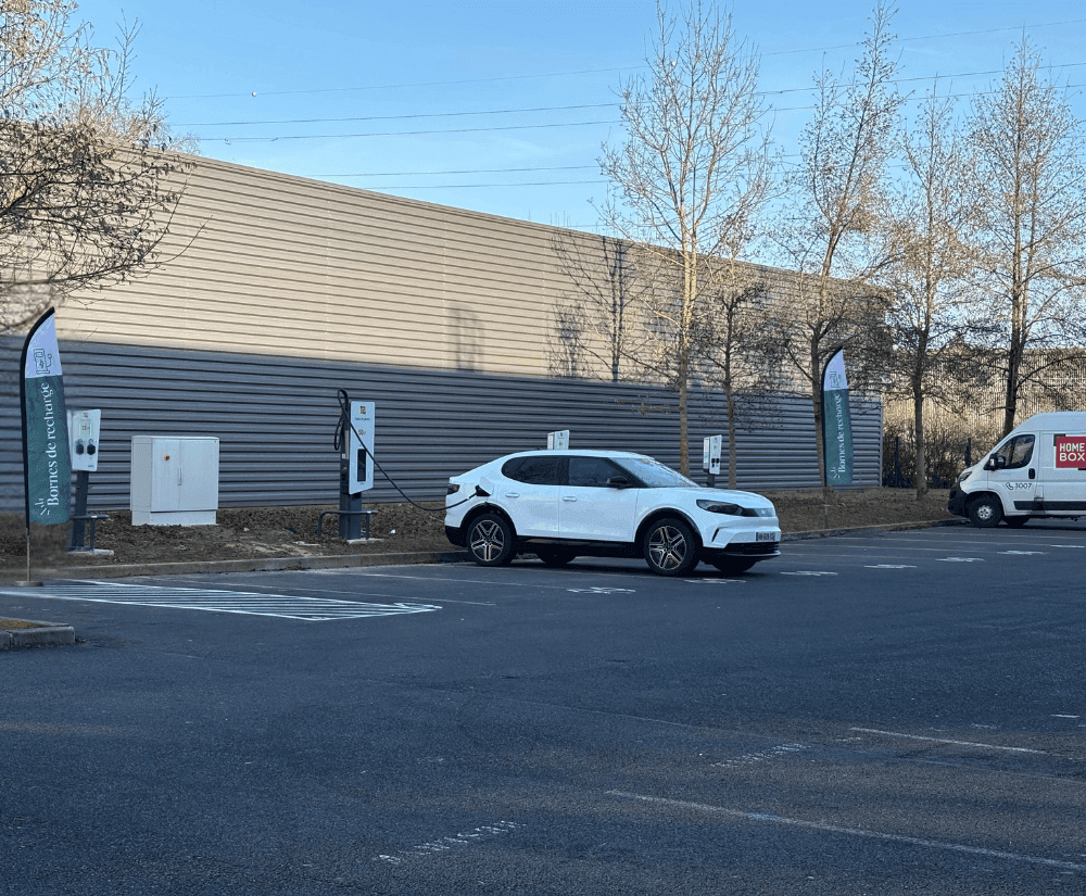 Bâtiment extérieur avec bornes et véhicule sur parking, HOMEBOX Evry-Courcouronnes, 14 avenue du bois de l'épine à Courcouronnes