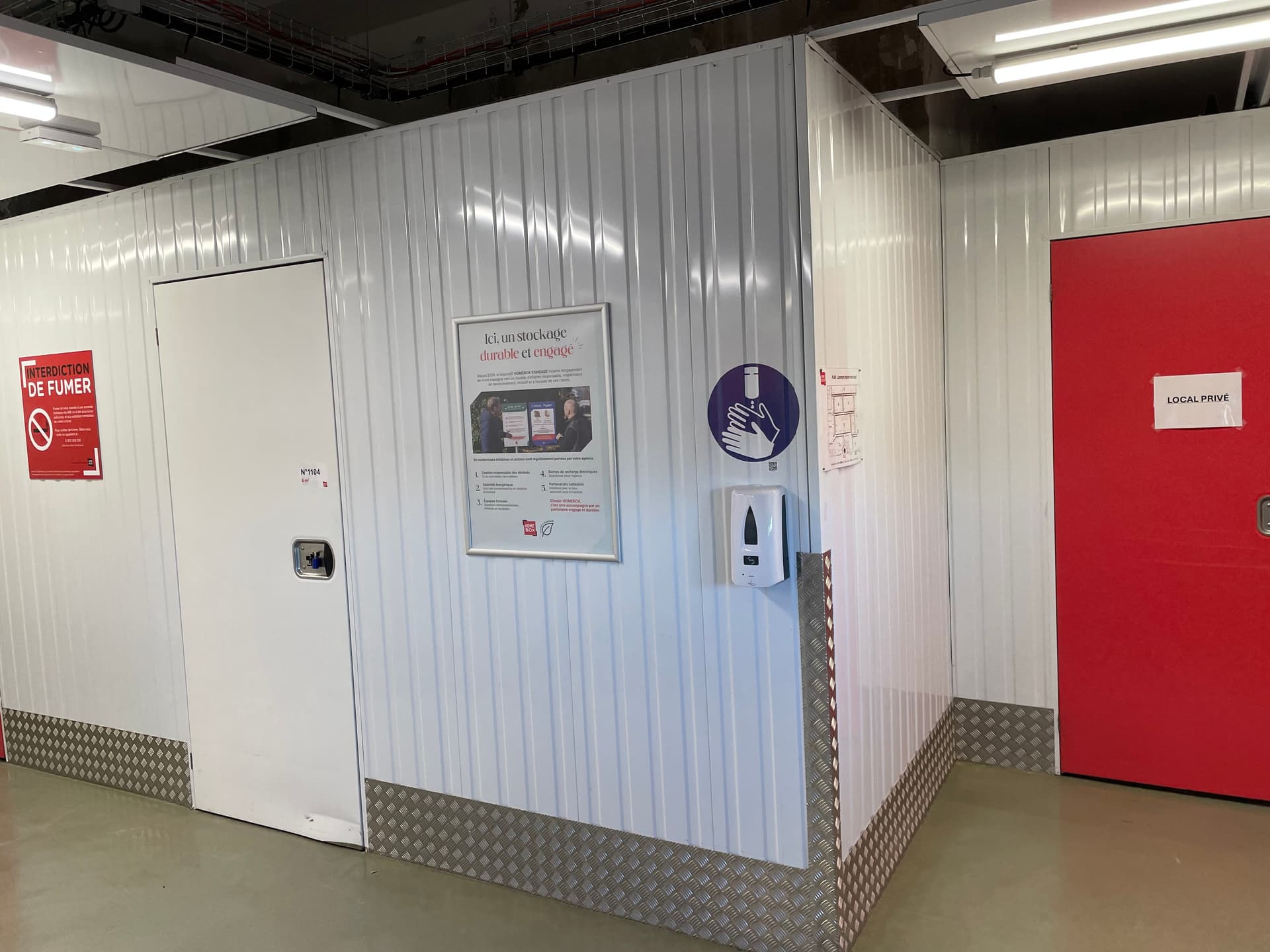 Couloir intérieur avec porte de box, affichage stockage durable et borne de gel hydroalcoolique du centre HOMEBOX Troyes