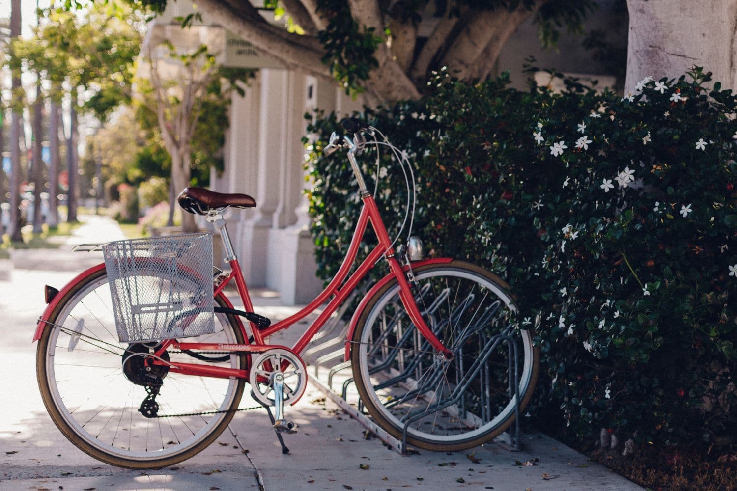 Vélo de ville rouge garé sur un rack dans la rue