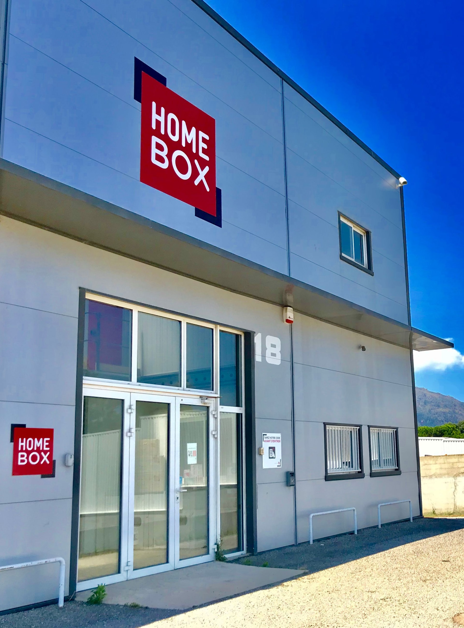 Façade du centre HOMEBOX Bastia avec entrée vitrée et logo HOMEBOX.