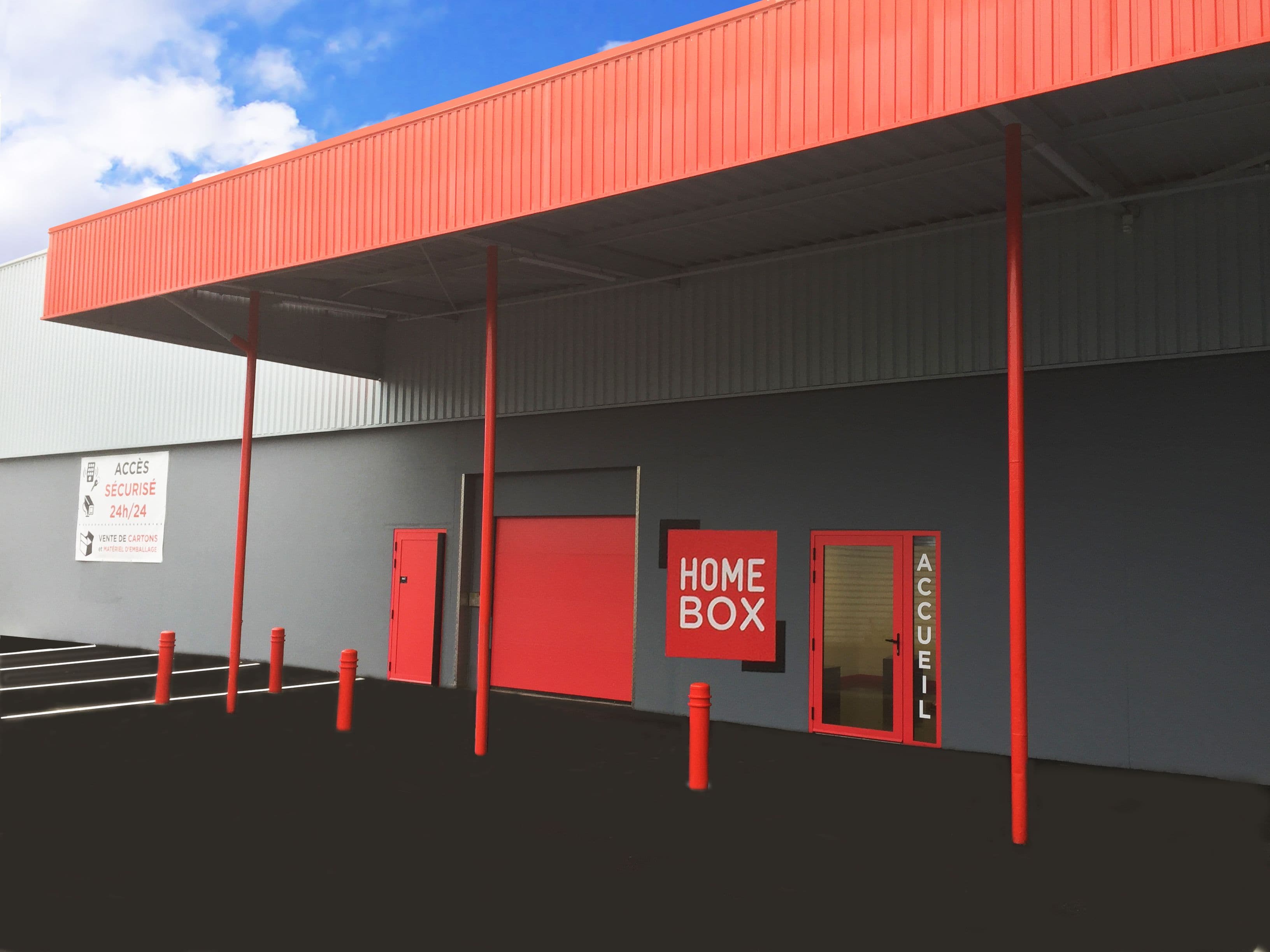 Entrée principale du centre HOMEBOX Dreux à Vernouillet avec auvent rouge et vitrine.
