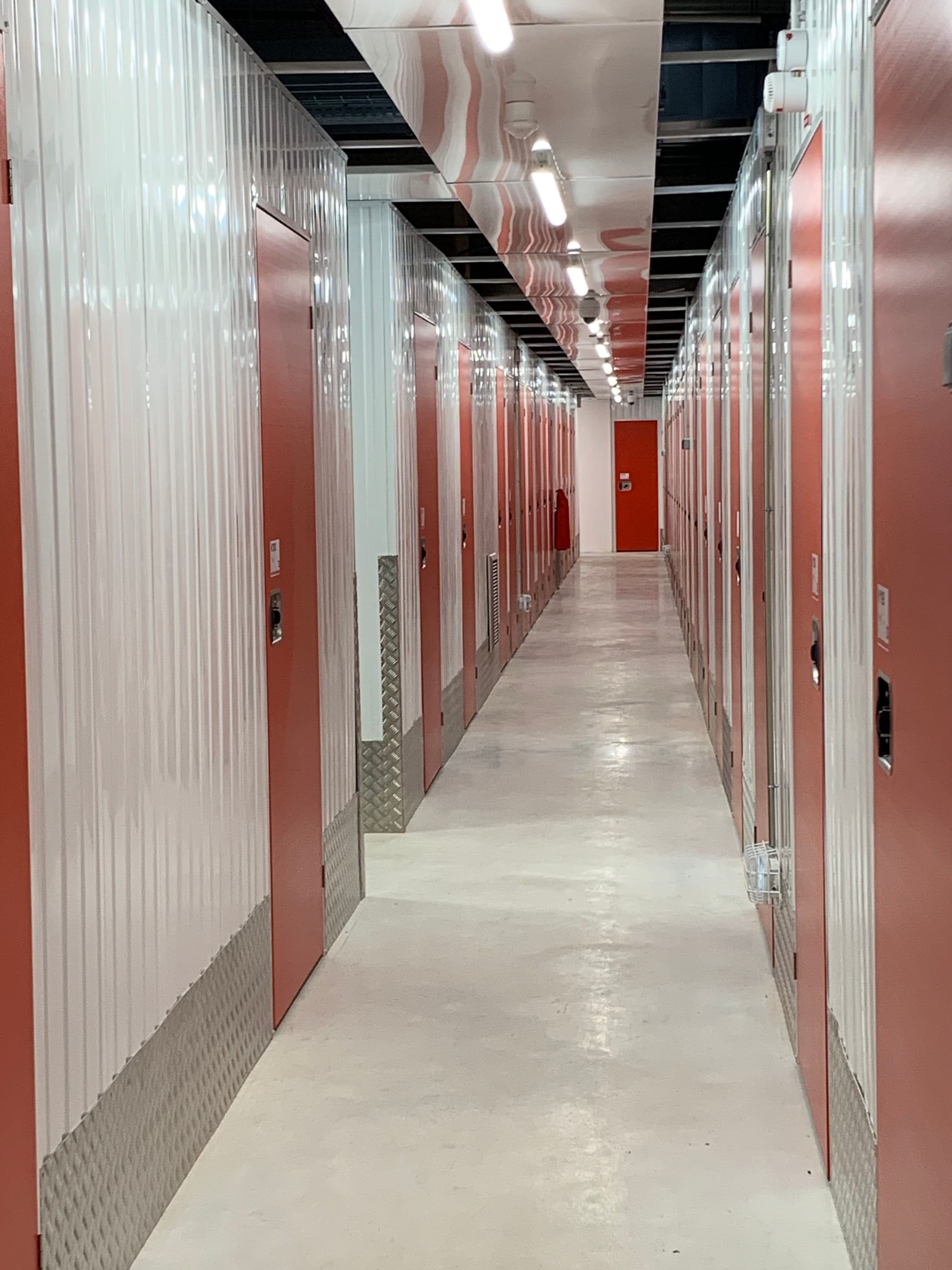 Couloir de box de stockage du centre HOMEBOX Amiens - Glisy avec portes rouges.