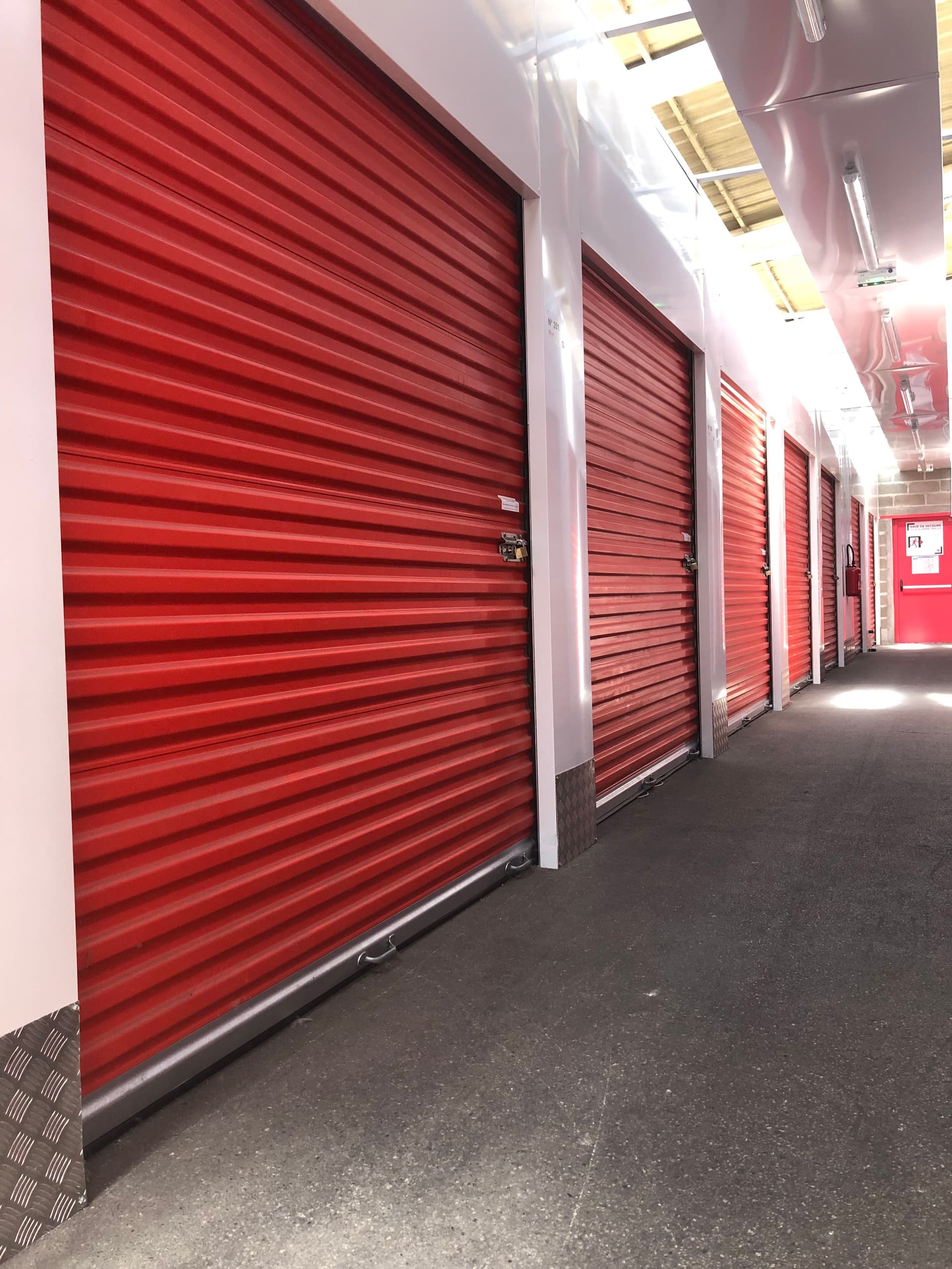 Couloir de box de stockage du centre HOMEBOX Amiens avec portes roulantes rouges