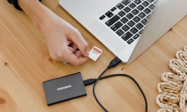 Personne sauvegardant des données sur un disque dur externe