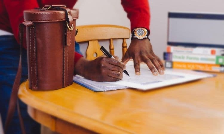 personne signant un contrat sur une table