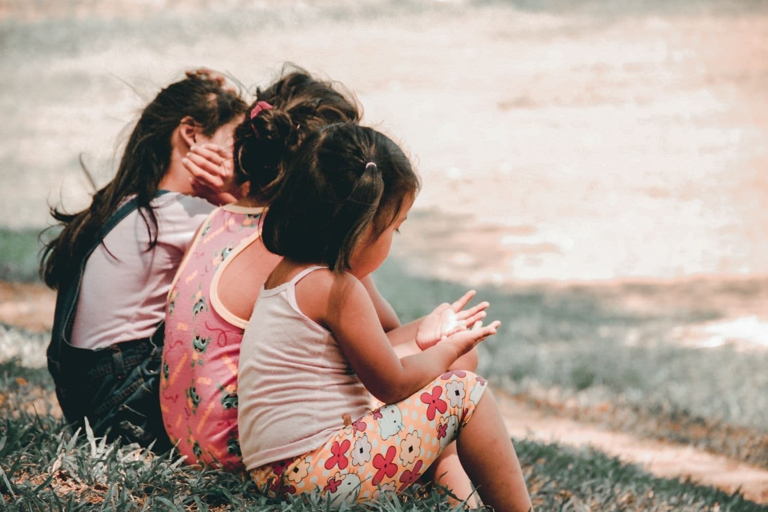 trois enfants dans l’herbe