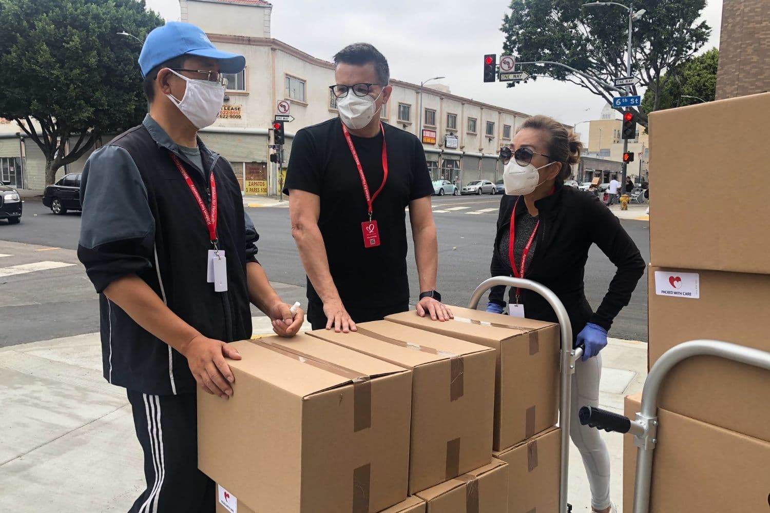 trois personnes qui déménagent des cartons dans la rue