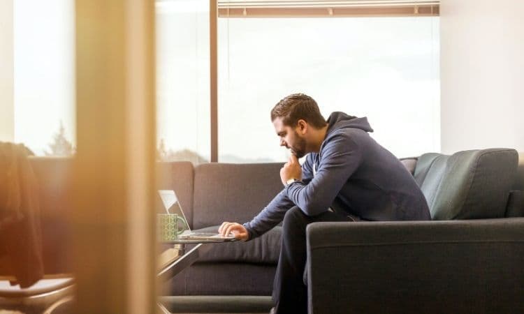 homme dans son salon sur son ordinateur
