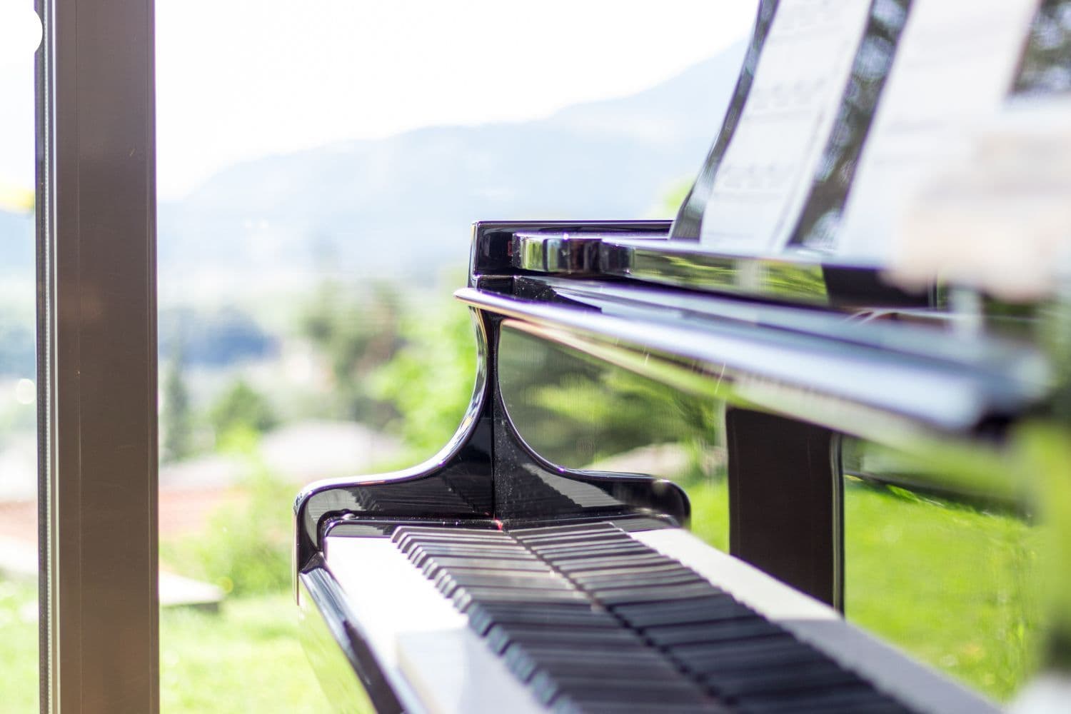 Piano à côté d’une fenêtre donnant sur un jardin