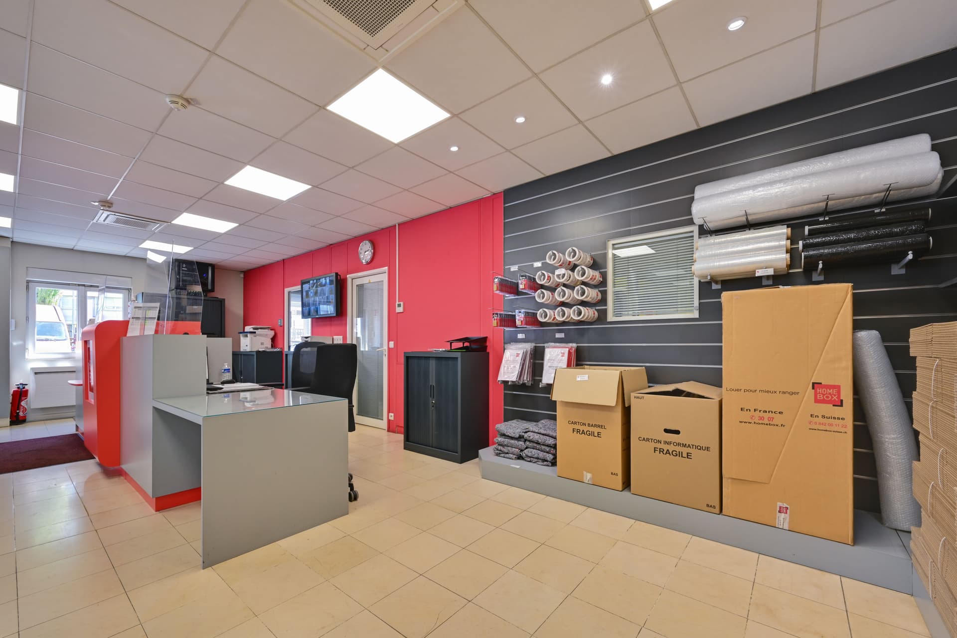 Vue générale de l’espace d’accueil du centre HOMEBOX Bagnolet avec comptoir et présentoirs de fournitures.
