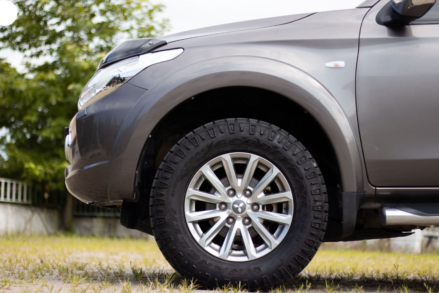 Gros plan sur le pneu d’une voiture stationnée dans l’herbe