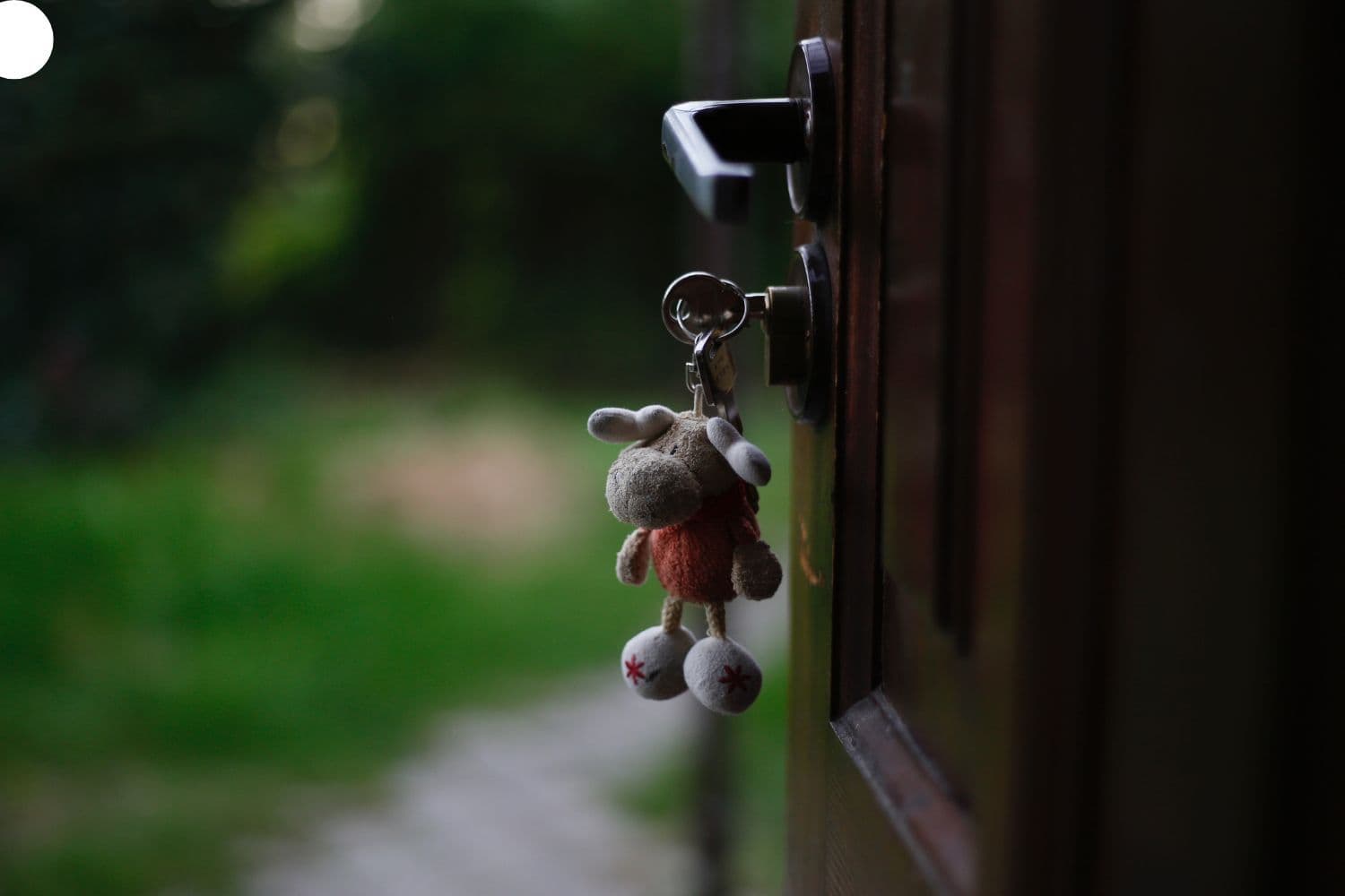 Clé dotée d’un porte-clé en peluche dans la serrure d’une porte
