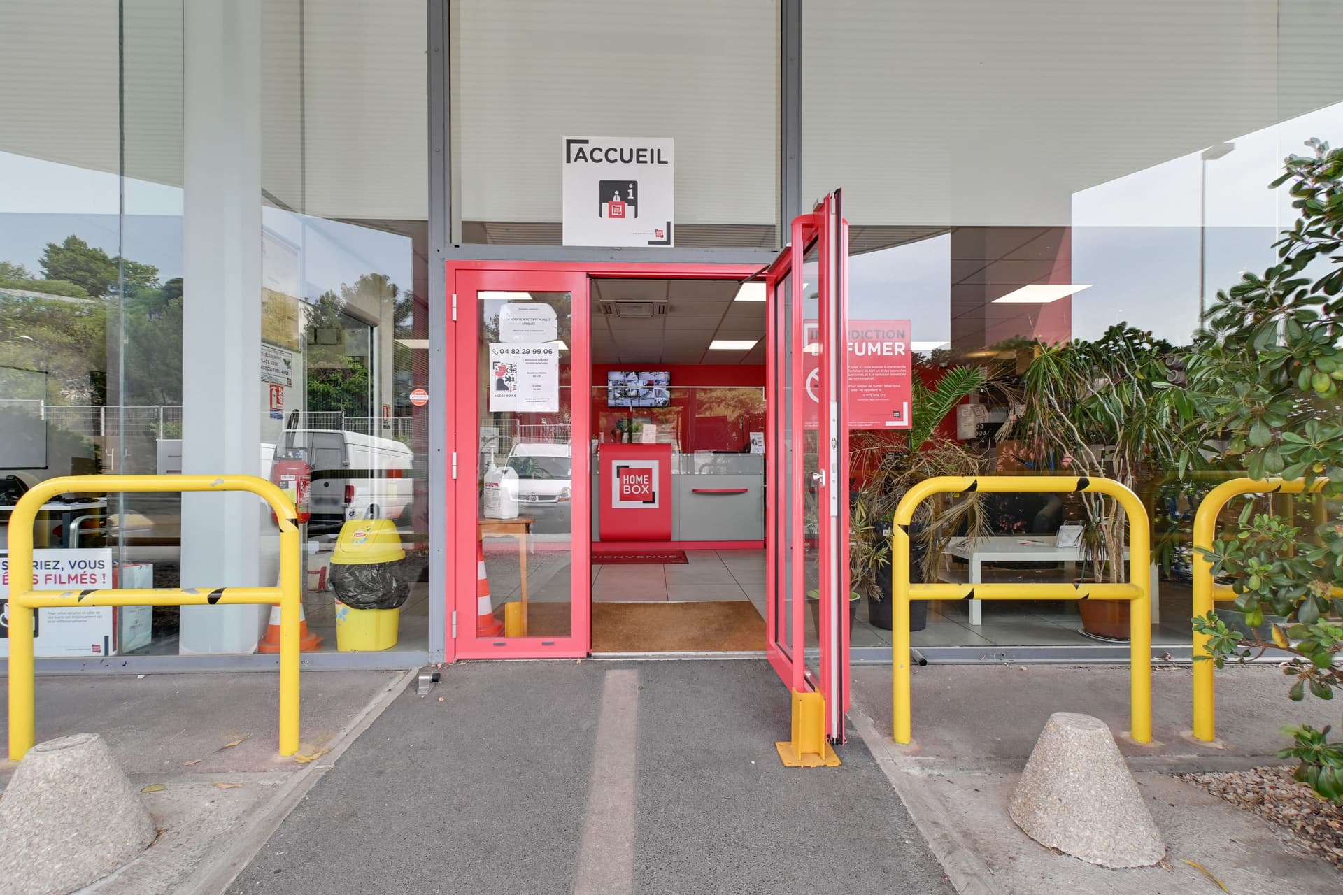 Entrée Accueil avec porte vitrée rose et barrières jaunes de sécurité, HOMEBOX Marseille - Plombières, 43 Boulevard Guigou à Marseille