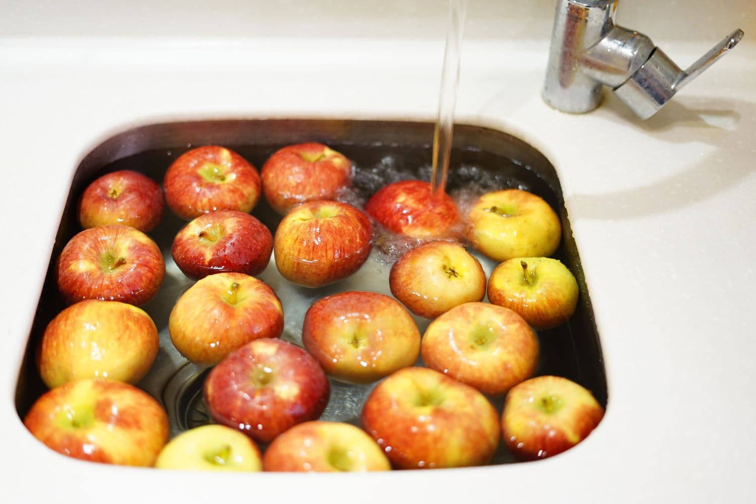 Pommes dans un évier rempli d’eau