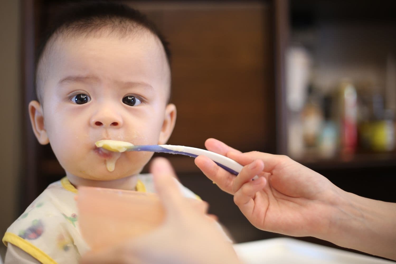 Bébé dubitatif à qui l’on donne une purée
