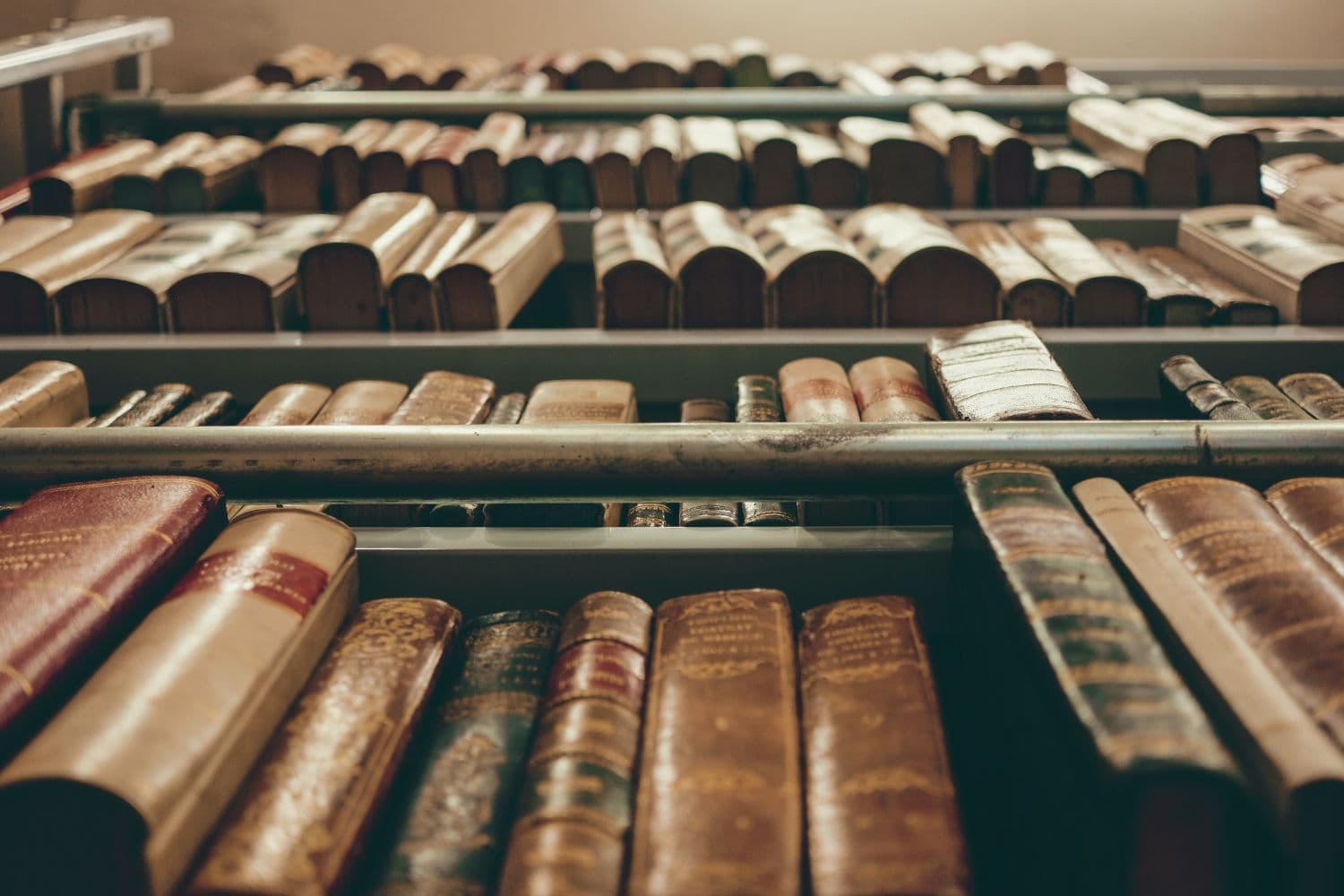 Vue en contre-plongée sur des livres anciens posés sur une étagère