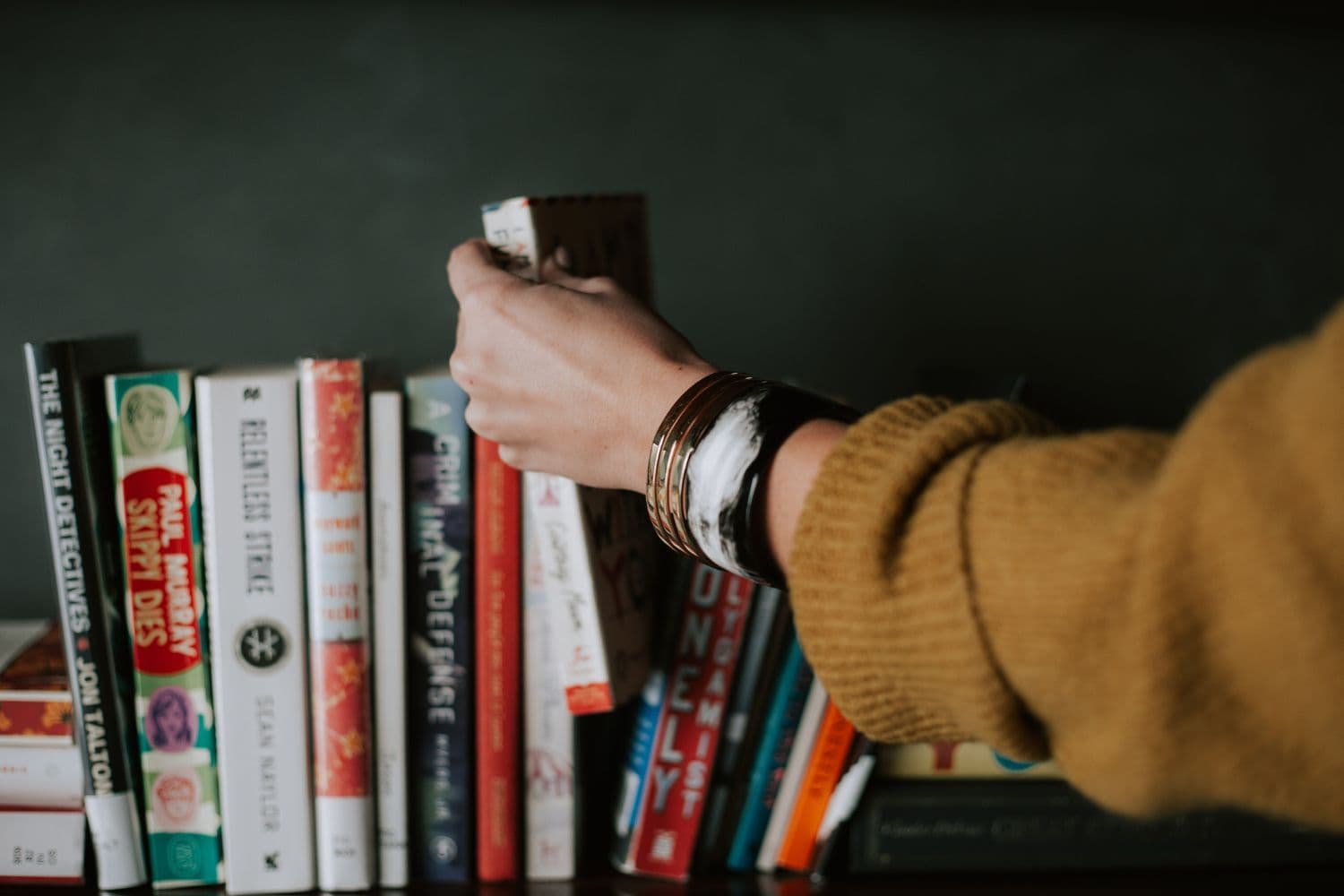 Personne choisissant un livre parmi plusieurs ouvrages