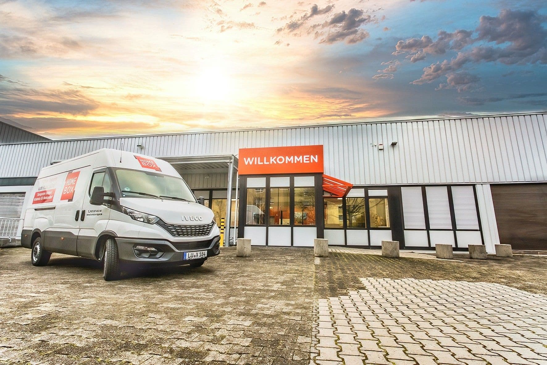 Branded white van parked outside the Willkommen entrance at sunset at HOMEBOX Ludwigshafen am Rhein, Bliesstraße 9, Ludwigshafen am Rhein