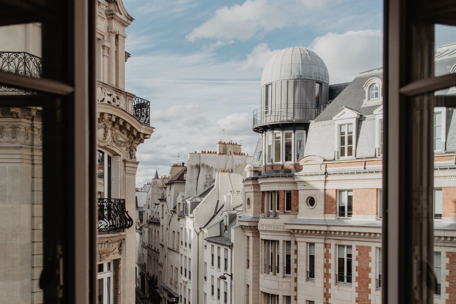 Vue sur des immeubles parisiens depuis une fenêtre en étage