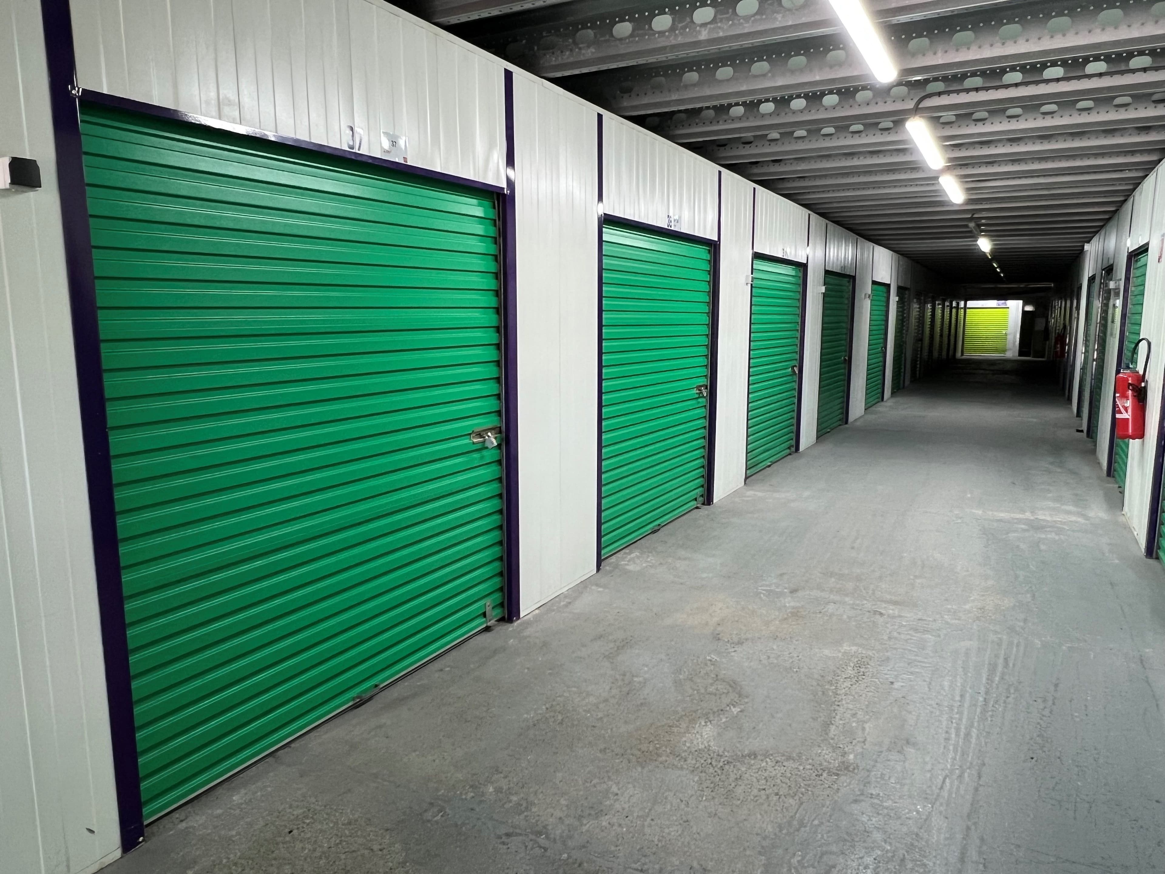 Couloir intérieur avec portes roulantes vertes au centre HOMEBOX Biot.