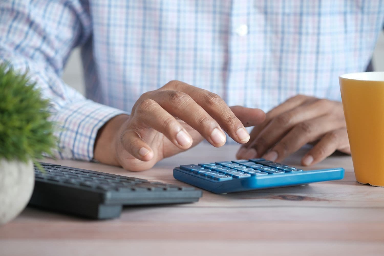 Personne en chemise utilisant une calculatrice