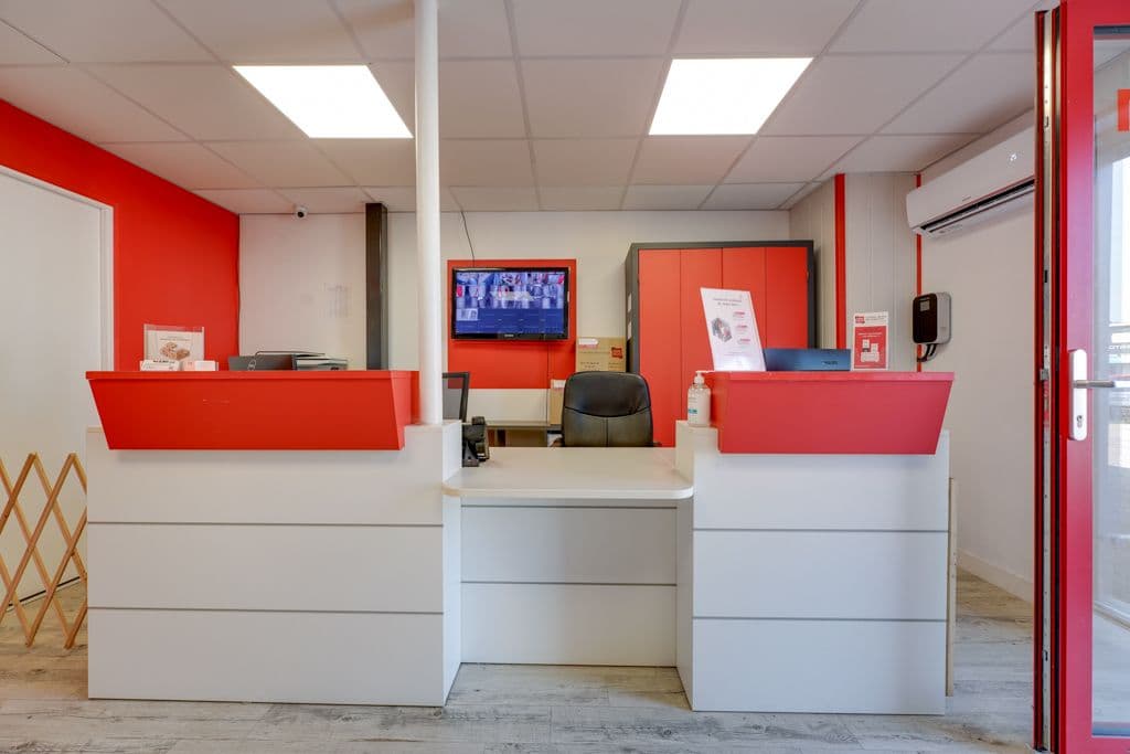 Accueil du centre HOMEBOX Chambéry avec comptoir moderne et écrans de vidéosurveillance