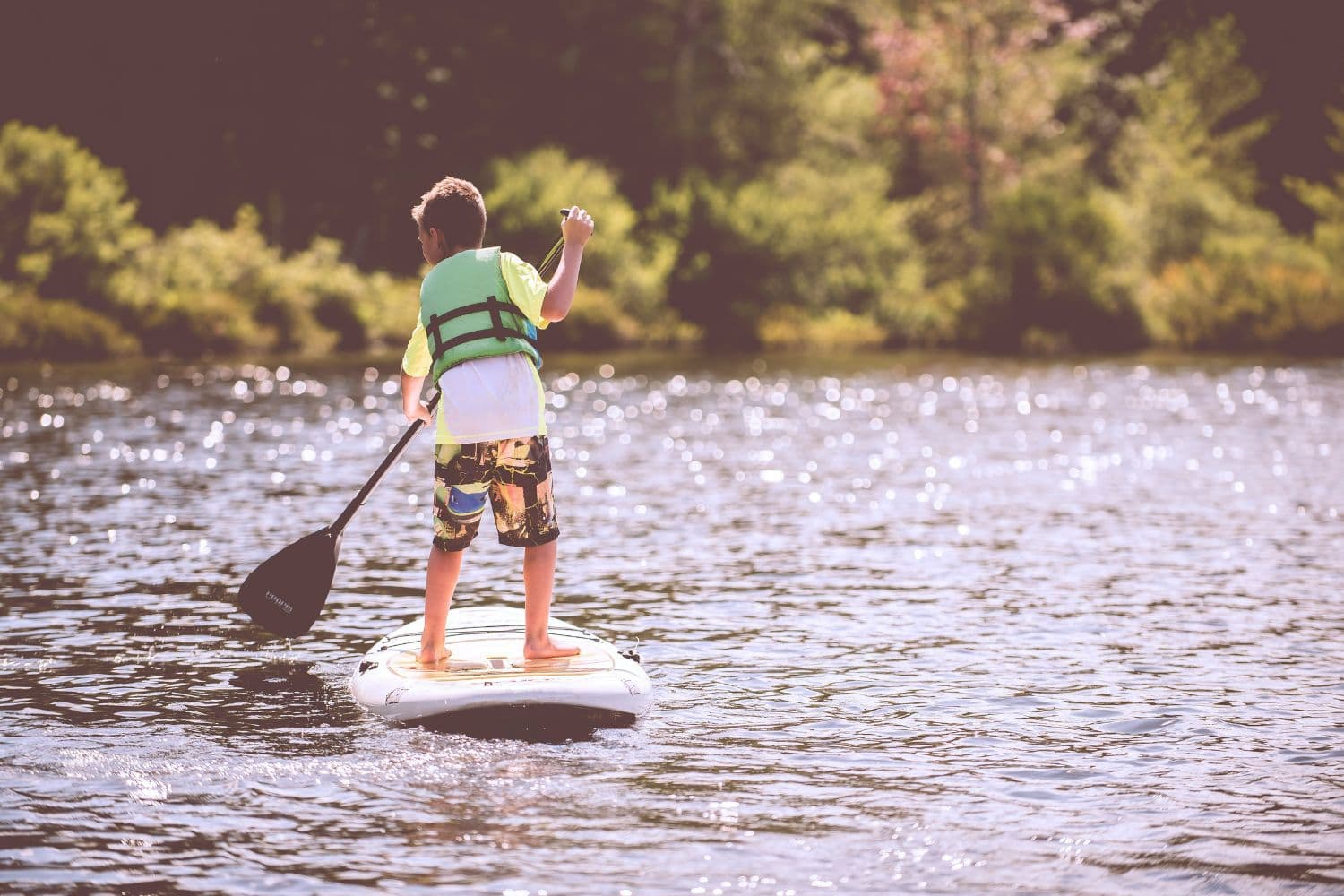 Enfant équipé d’un gilet de sauvetage sur un stand up paddle