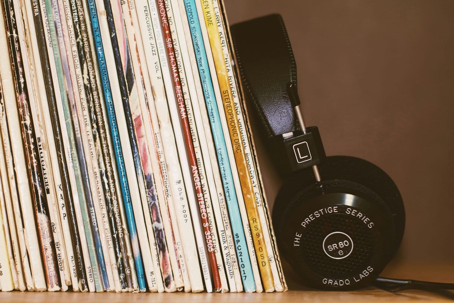 Vinyles placés debout contre un casque audio noir