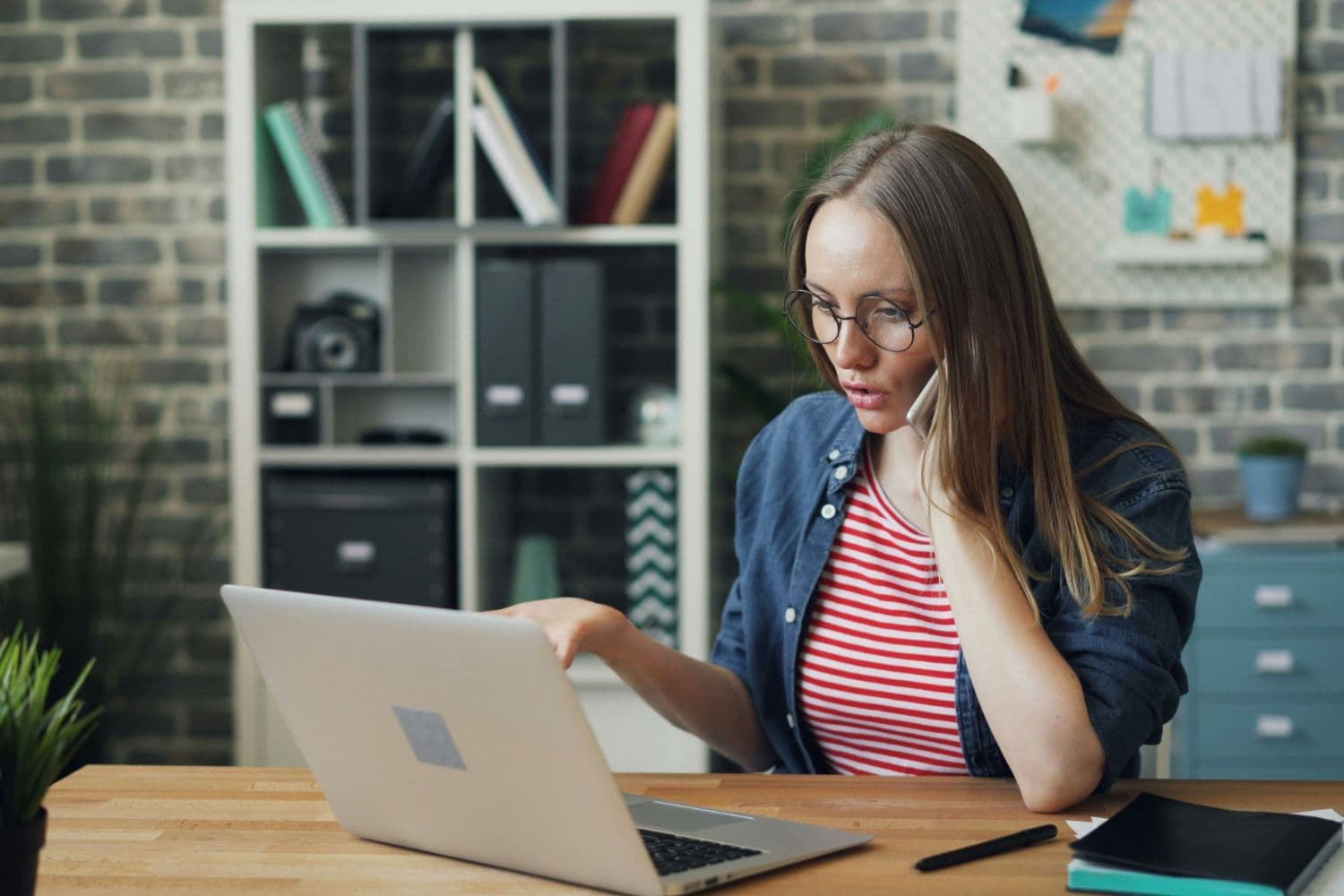 Personne au téléphone devant un ordinateur portable