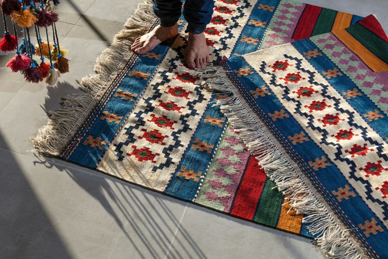 Personne en jean sur un tapis multicolore