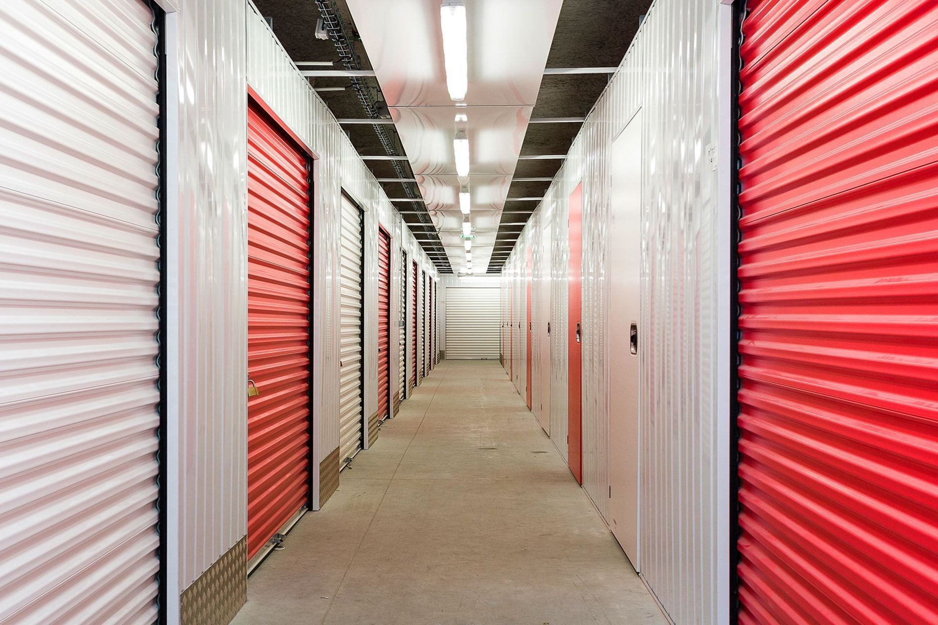 Couloir intérieur avec rangées de portes de boxes rouges et blanches du centre HOMEBOX La Rochelle