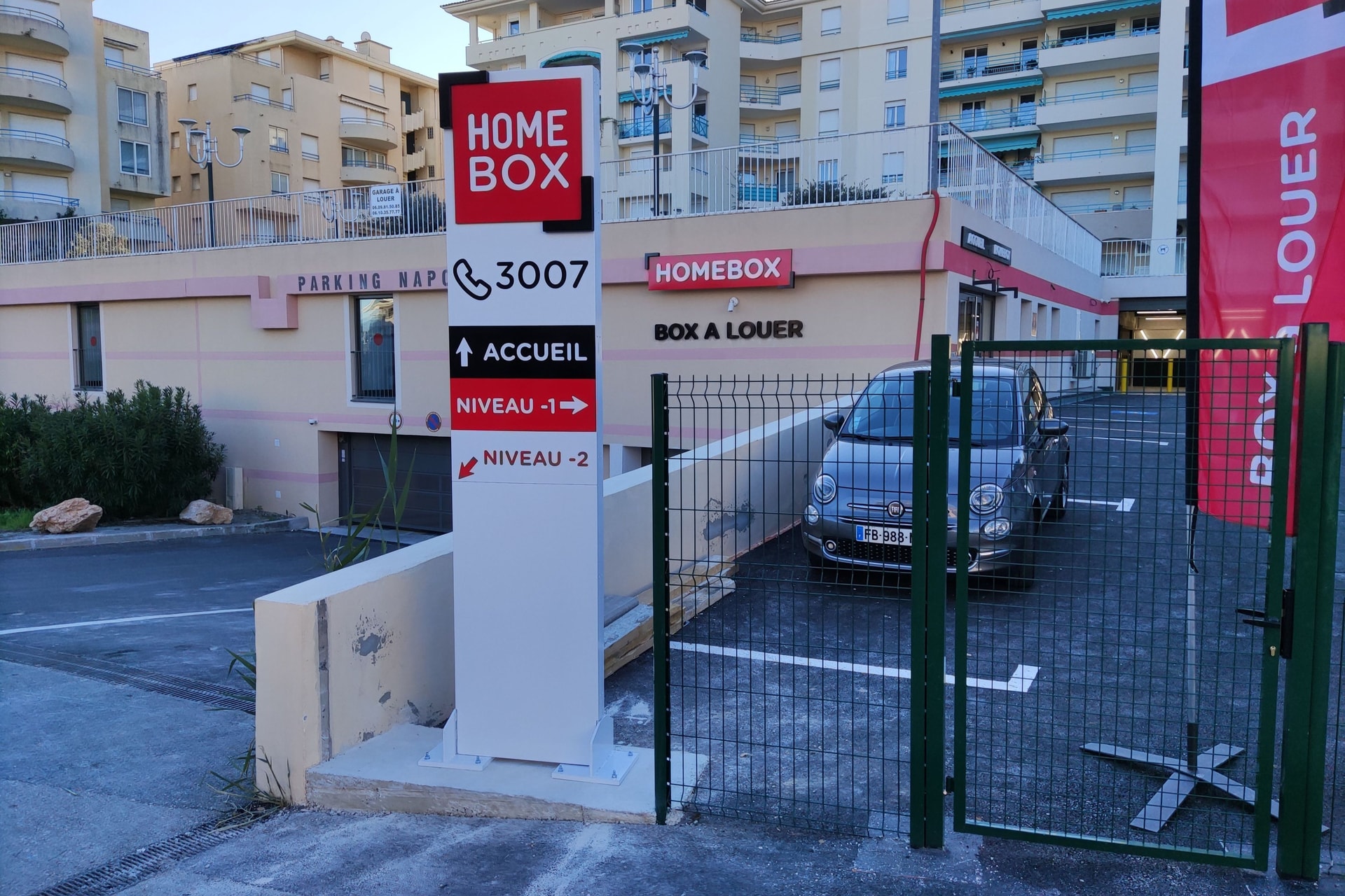 Entrée du centre HOMEBOX Antibes-les-Pins, avenue de Cannes à Juan-Les-Pins, avec panneau d’indication et portail vert.