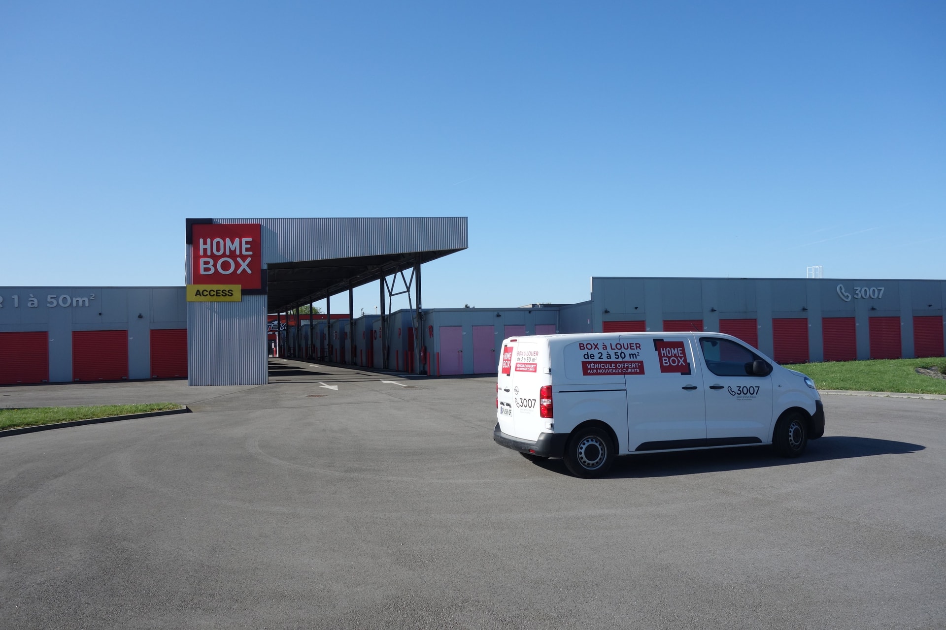 Parking extérieur avec utilitaire HOMEBOX devant rangée de boxes rouges, HOMEBOX Vannes Sud, Allée Nicolas Appert à Vannes