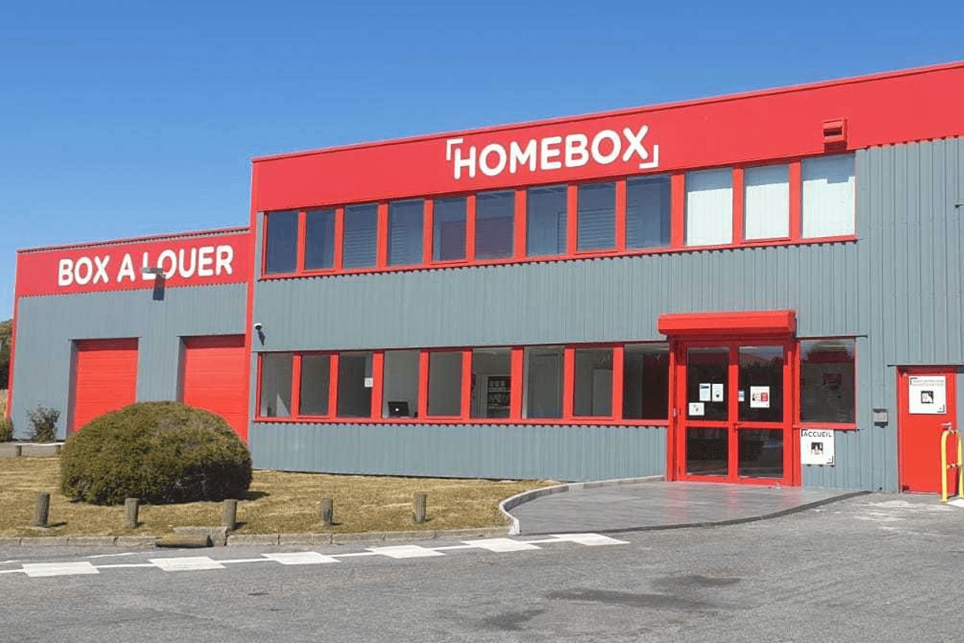 Façade rouge et grise avec enseigne HOMEBOX et entrée accueil vitrée, HOMEBOX Maurepas, 7 rue Claude Bernard à Maurepas