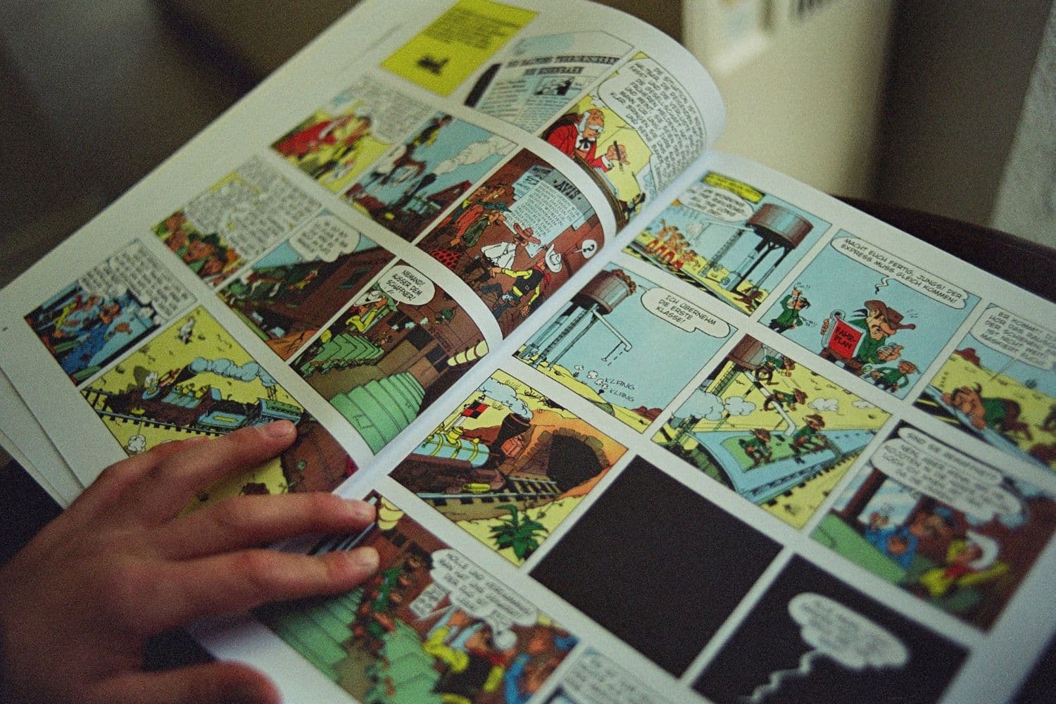 Gros plan sur une main tenant une bande dessinée ouverte