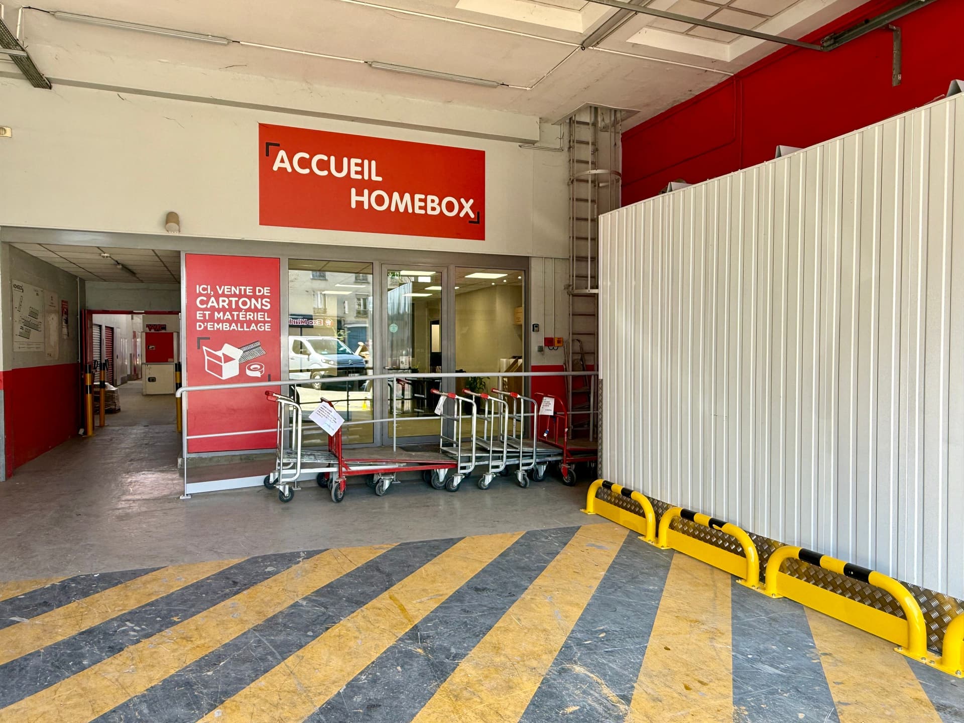 Entrée de l'accueil avec chariots de transport et signalétique vente de cartons du centre HOMEBOX La Villette-Aubervilliers