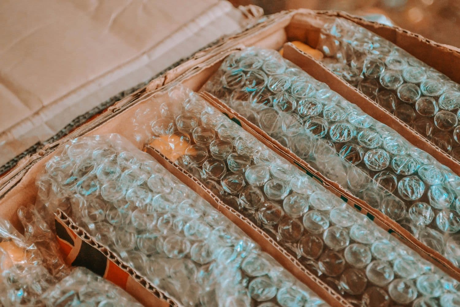 Objets emballés dans du papier bulle et disposés dans un carton