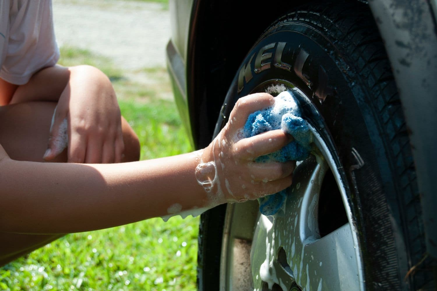 Personne entretenant les jantes de sa voiture