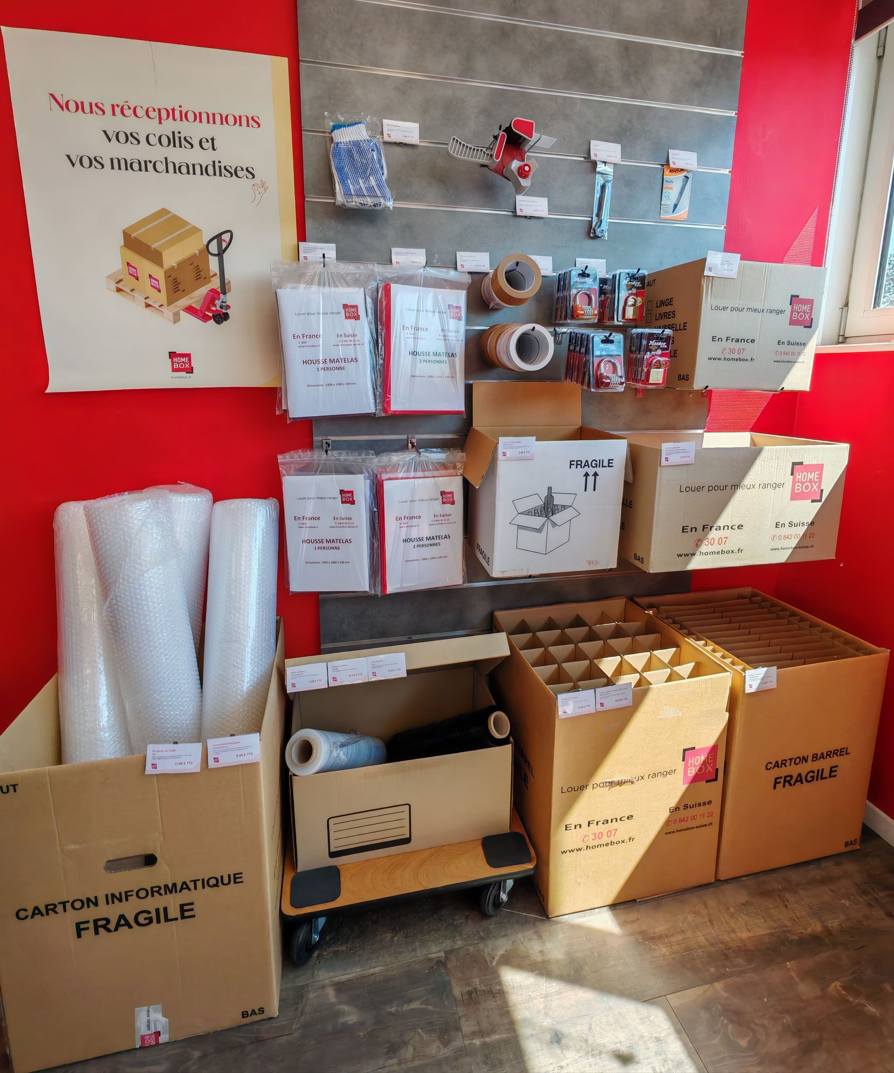Fournitures de déménagement en vente au centre HOMEBOX Bayeux, avec cartons, rouleaux de film et rubans adhésifs.