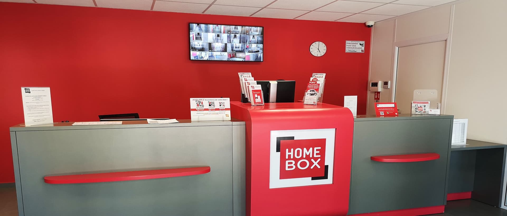 Comptoir d’accueil rouge et gris au centre HOMEBOX Caen Est.