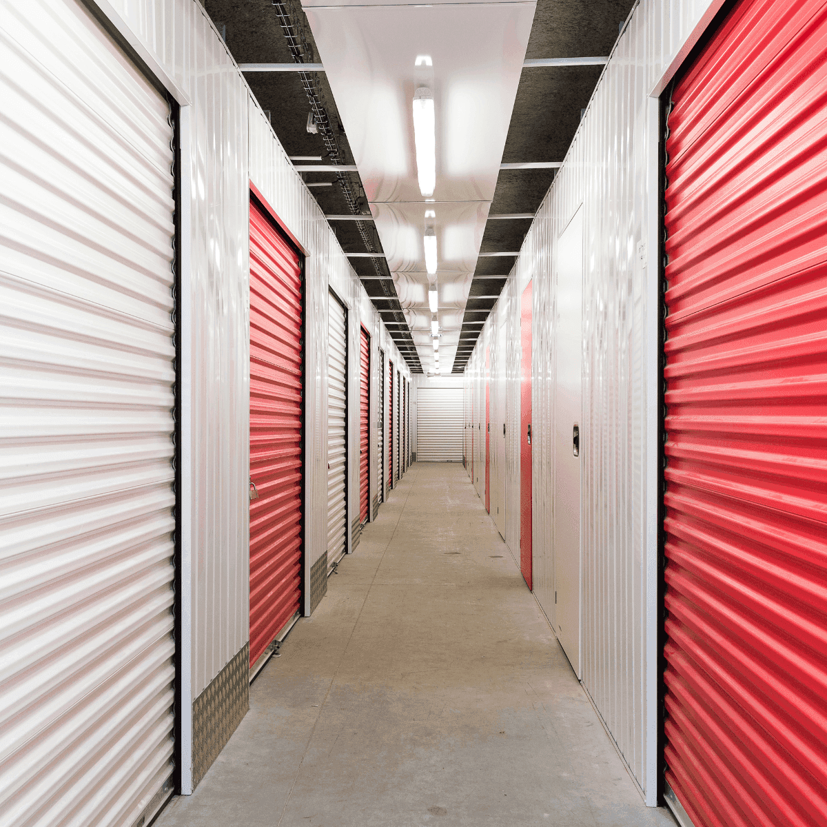 Couloir intérieur avec box rouges et blancs au centre HOMEBOX Corte.