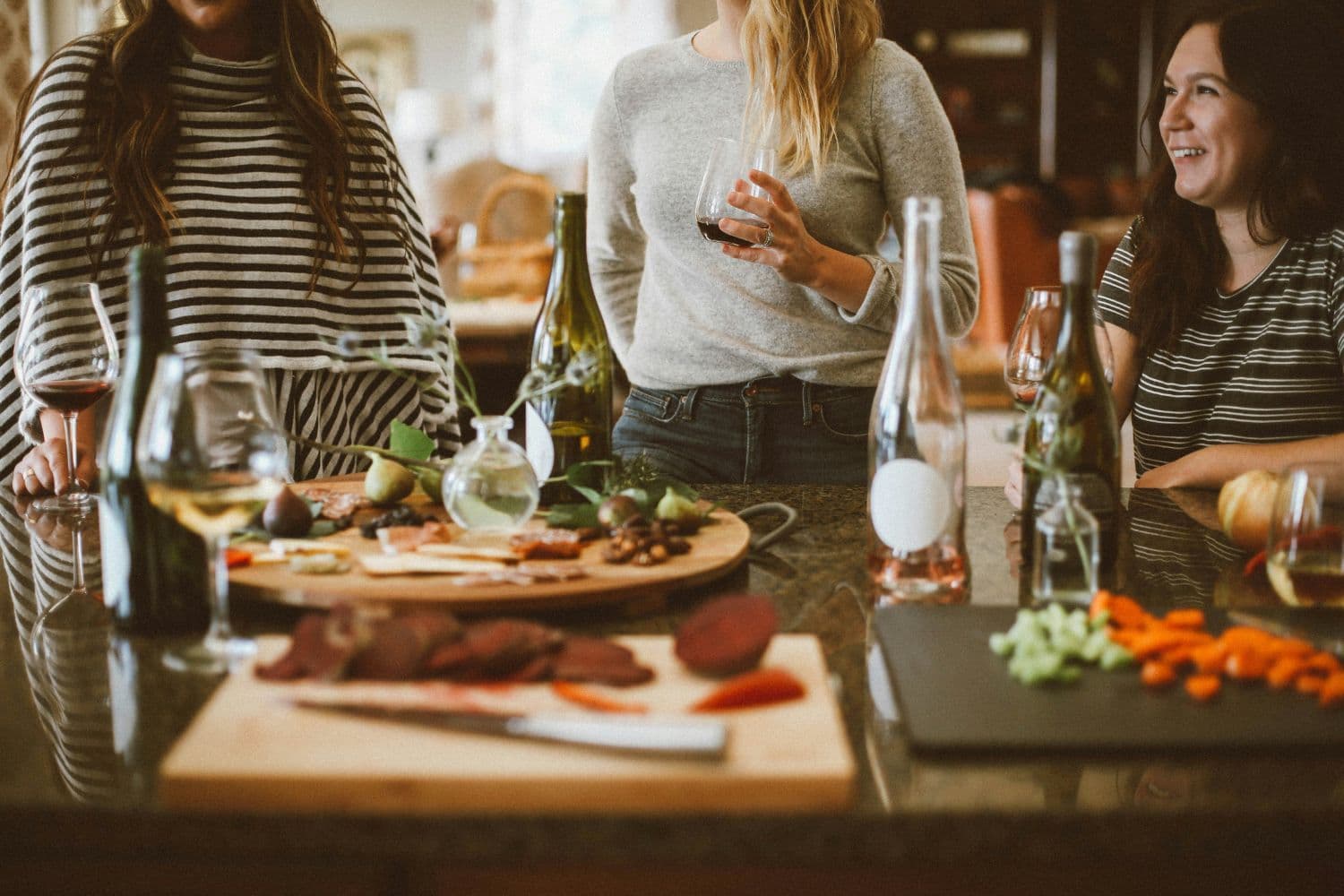 Plusieurs personnes autour d’une table un verre à la main pendant une crémaillère