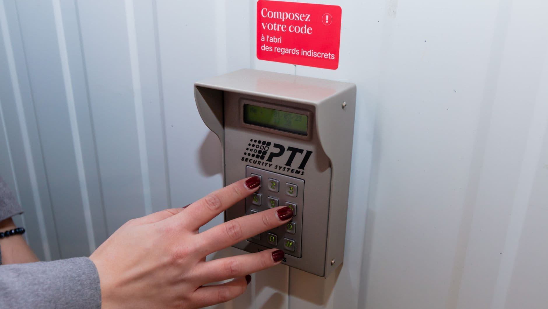 Gros plan sur une personne composant un code sur un digicode de box de stockage