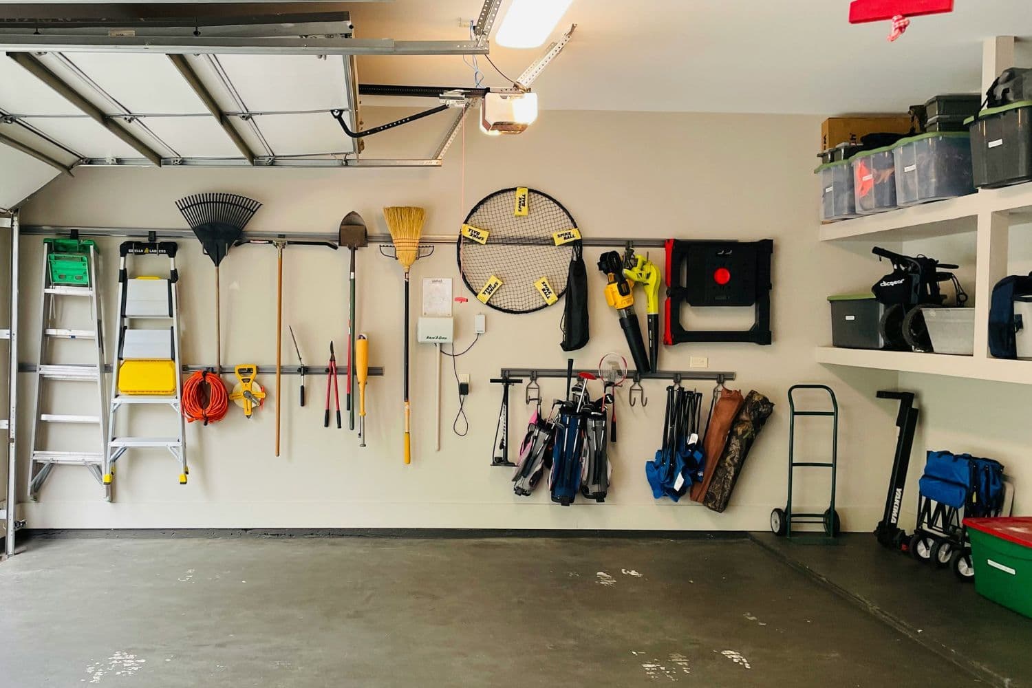 Vue paysage sur un grand garage avec différents outils au mur et le sol dégagé