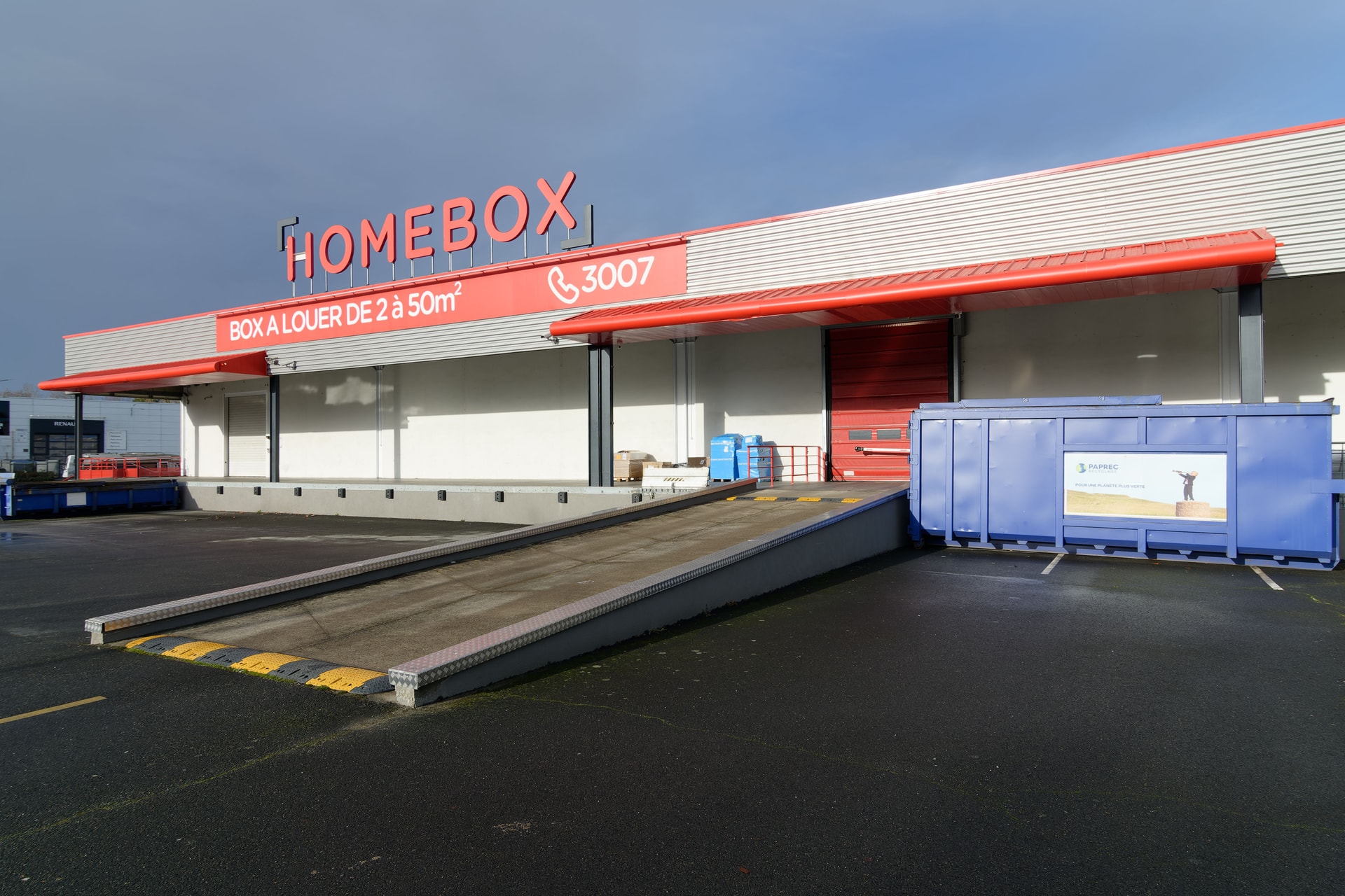Façade avec enseigne HOMEBOX, quai de chargement et benne de recyclage, 2 rue du Danemark à Carquefou