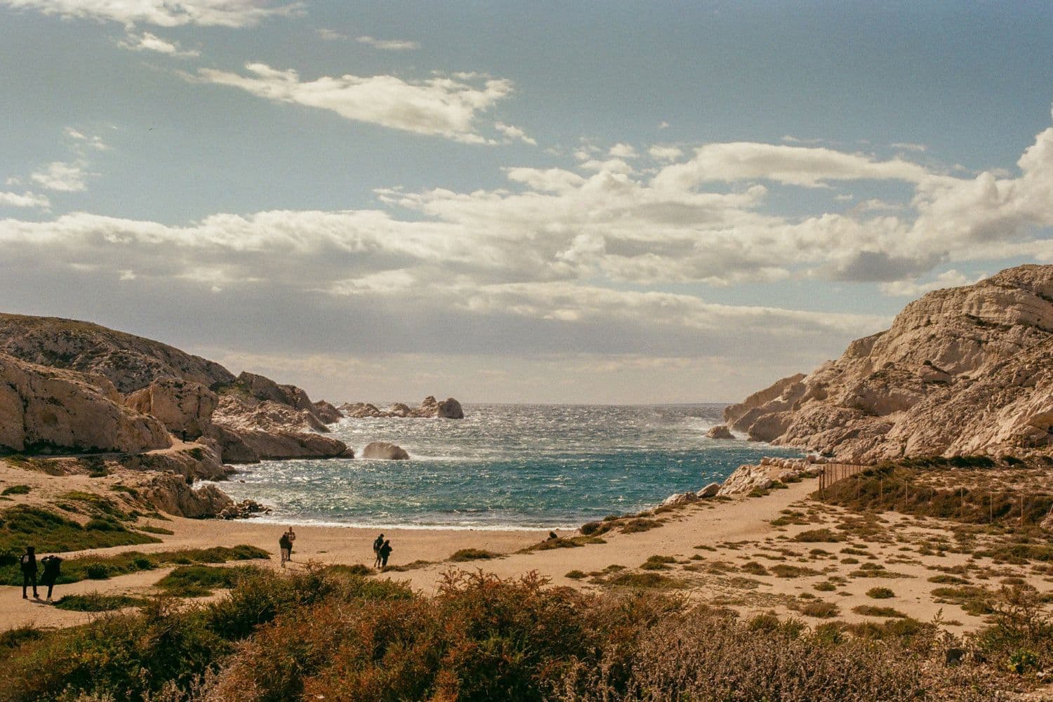 Plage d’une île du Frioul, falaises de part et d’autre et végétation au premier plan