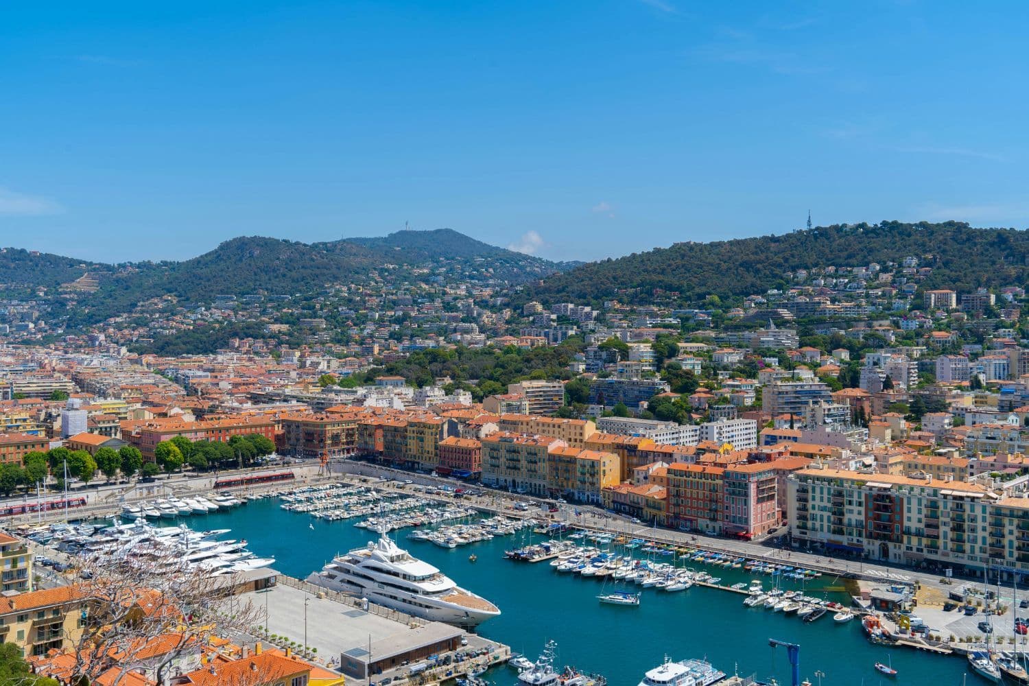 Vue surplombante sur le vieux port de Marseille, yacht imposant et nombreux bâteaux de plaisance amarrés par beau temps