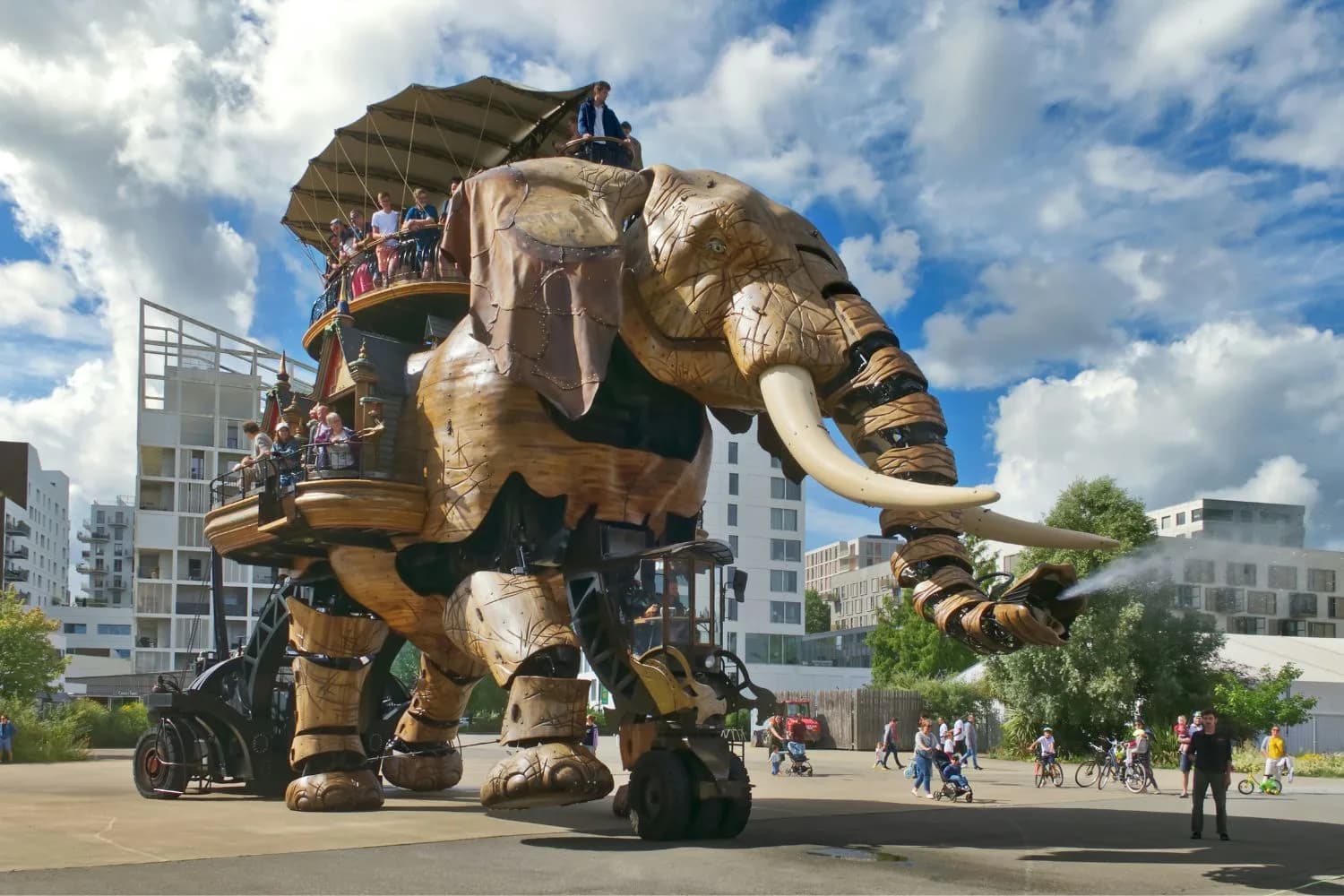 Éléphant mécanique arrosant des passants par beau temps